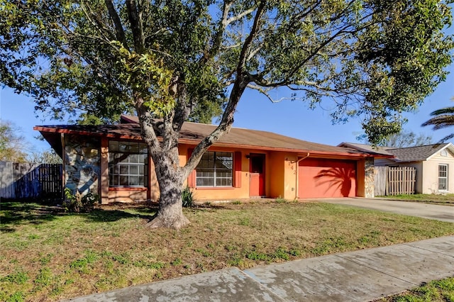 ranch-style home featuring a garage and a front lawn