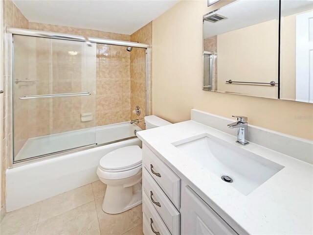 10346 Carrollwood Ln Unit 171, Tampa, FL 33618 - full bathroom featuring combined bath / shower with glass door, vanity, tile patterned floors, toilet, and visible vents