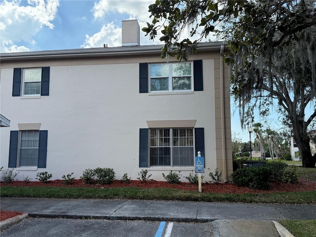 10346 Carrollwood Ln Unit 171, Tampa, FL 33618 - view of front of home featuring a chimney and stucco siding