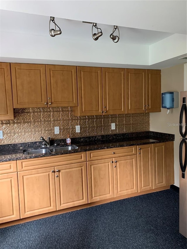 10346 Carrollwood Ln Unit 171, Tampa, FL 33618 - kitchen featuring refrigerator, brown cabinets, dark stone counters, decorative backsplash, and a sink