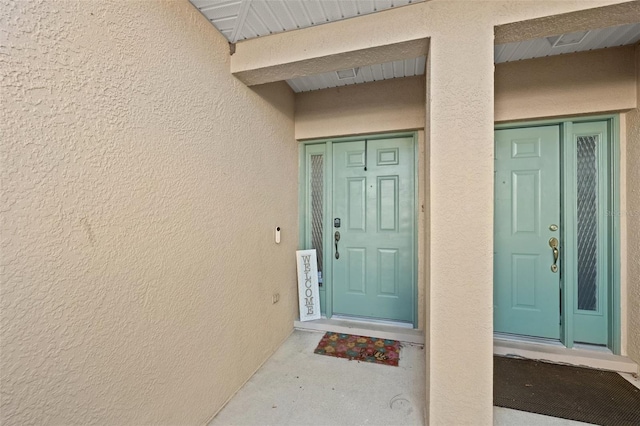 entrance to property featuring stucco siding