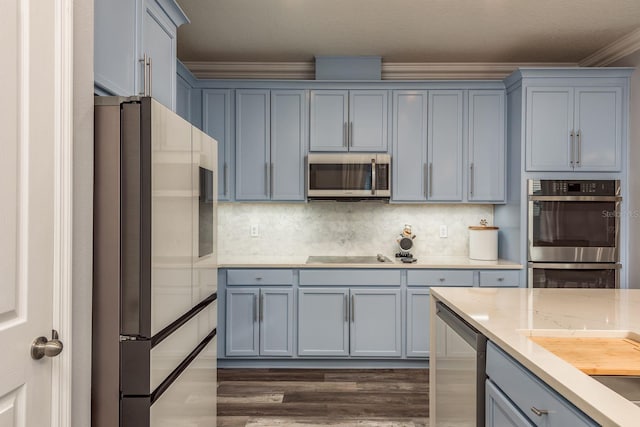 kitchen featuring appliances with stainless steel finishes, tasteful backsplash, dark hardwood / wood-style flooring, crown molding, and light stone countertops