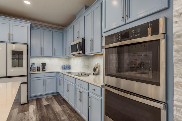 kitchen with backsplash, dark wood-type flooring, and stainless steel appliances