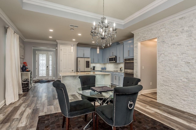 dining space featuring crown molding, dark hardwood / wood-style floors, and a chandelier