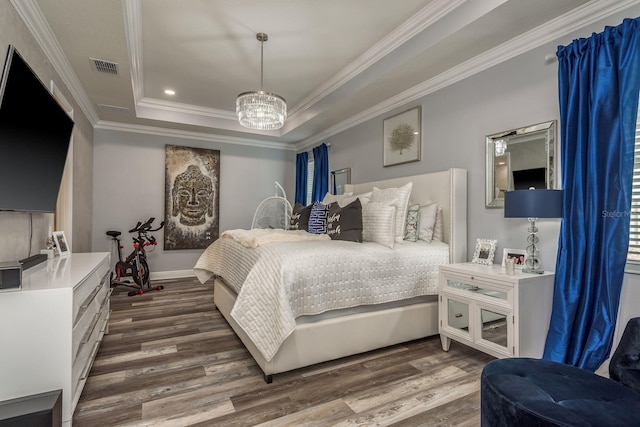 bedroom with crown molding, a chandelier, dark hardwood / wood-style flooring, and a tray ceiling