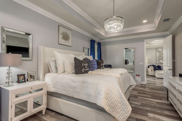 bedroom featuring dark hardwood / wood-style flooring, a tray ceiling, ornamental molding, and an inviting chandelier