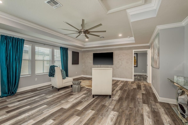 living area with crown molding, dark hardwood / wood-style flooring, and a tray ceiling