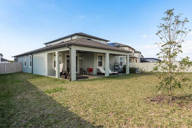 back of property featuring a patio area and a lawn