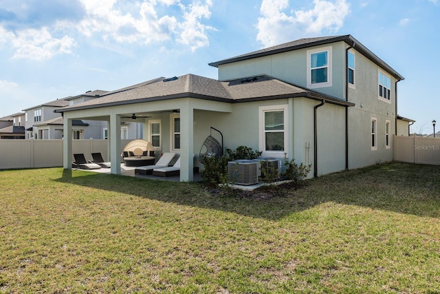 back of property with ceiling fan, a yard, a patio, an outdoor fire pit, and central AC unit