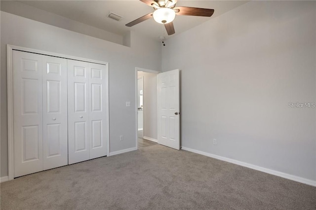 unfurnished bedroom featuring light carpet, ceiling fan, and a closet