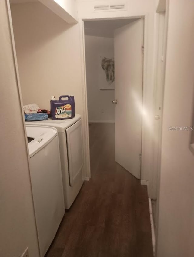 washroom with dark hardwood / wood-style floors and washing machine and dryer