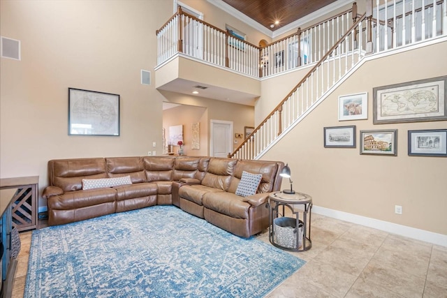 living room featuring tile patterned flooring, wood ceiling, ornamental molding, and a high ceiling