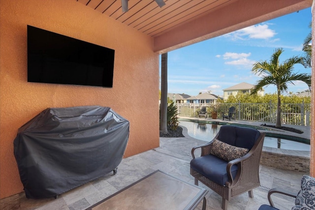 view of patio featuring area for grilling, a fenced in pool, and ceiling fan