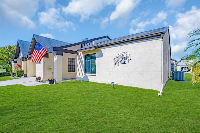 view of front of property featuring a garage, a front lawn, and central air condition unit