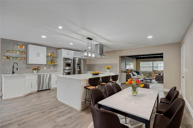 dining area with a chandelier, light hardwood / wood-style floors, and sink