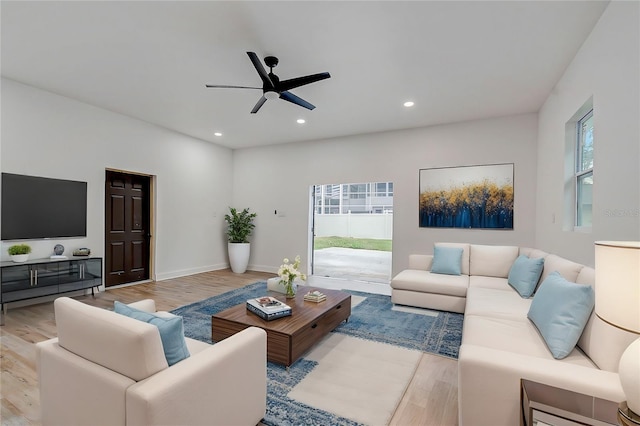 living room with ceiling fan, a healthy amount of sunlight, and light wood-type flooring