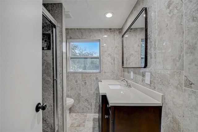 bathroom with vanity, tile walls, and toilet