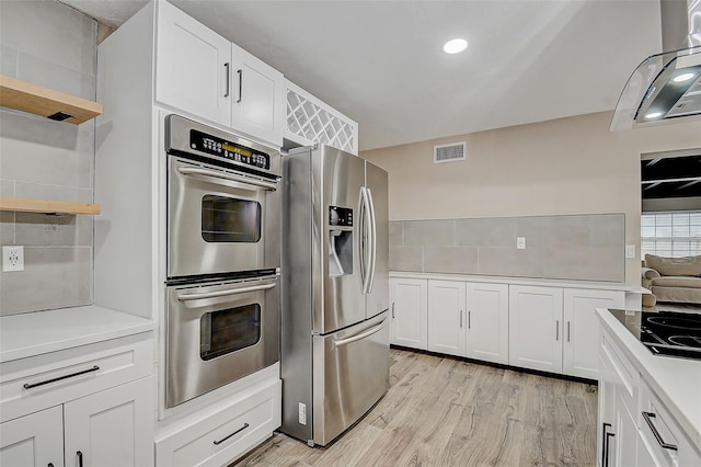 kitchen with stainless steel appliances, light hardwood / wood-style floors, and white cabinets