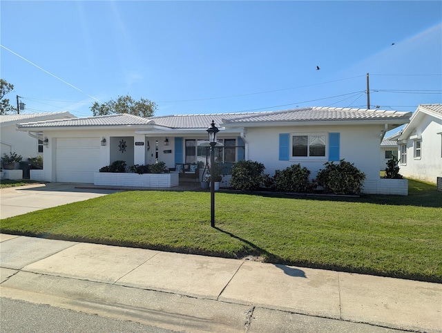 ranch-style home featuring an attached garage, driveway, a tile roof, and a front lawn