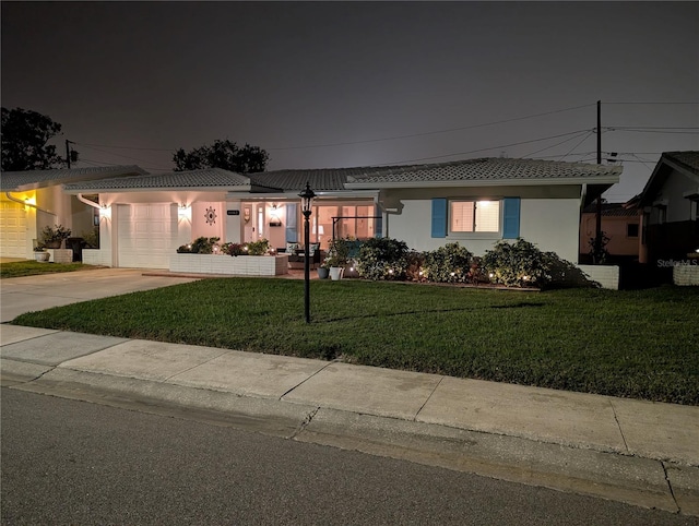 view of front of property with a front lawn, a garage, driveway, and stucco siding