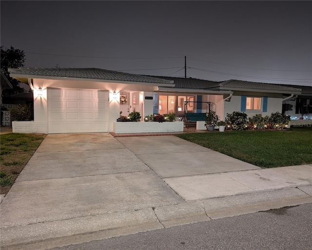 single story home with stucco siding, a lawn, concrete driveway, and an attached garage