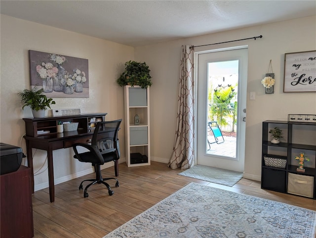 office space with baseboards and wood finished floors