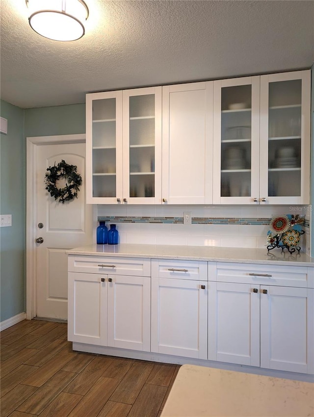 kitchen featuring white cabinetry, light countertops, and dark wood-type flooring