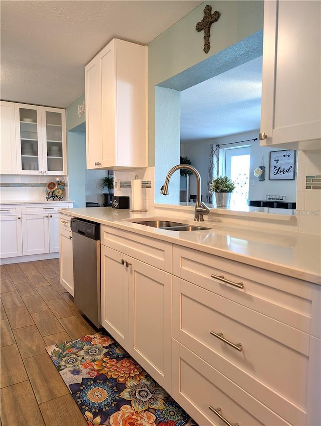 kitchen featuring a sink, white cabinetry, dishwasher, and light countertops