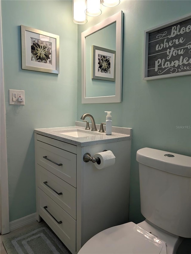 half bathroom with toilet and vanity