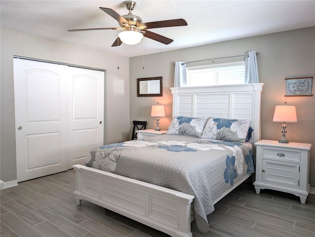 bedroom featuring a closet, ceiling fan, a textured ceiling, and wood finish floors