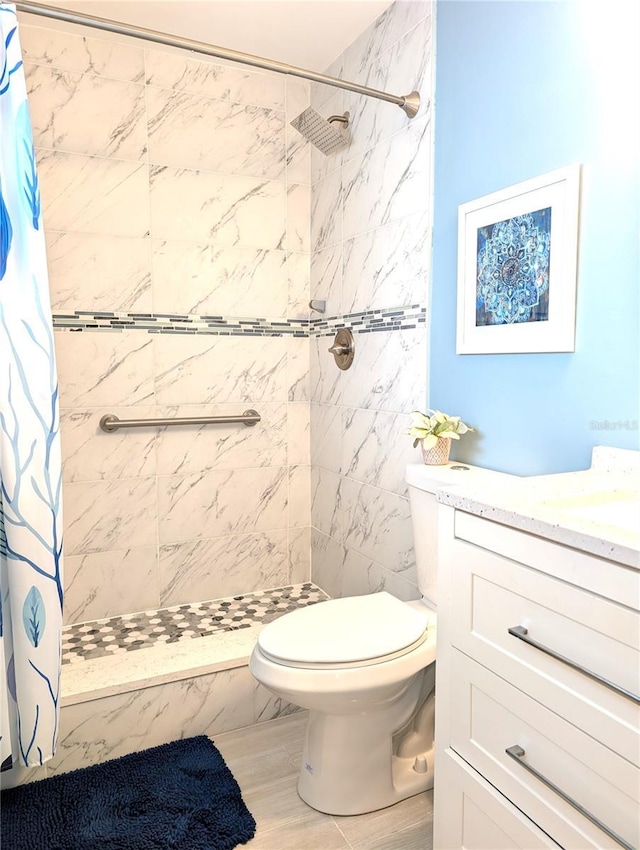 full bathroom featuring a shower stall, toilet, and vanity