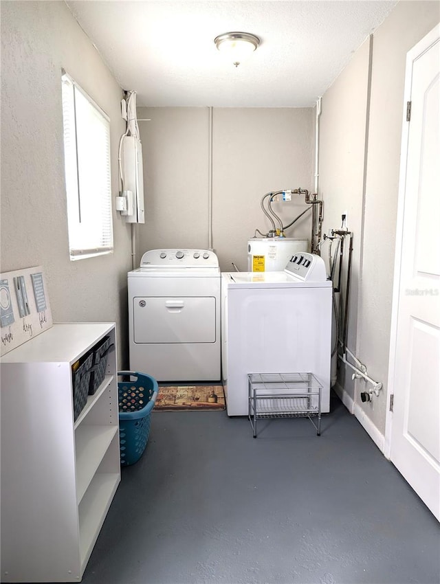 laundry area featuring electric water heater, washing machine and dryer, and laundry area