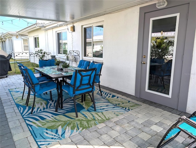 view of patio with outdoor dining space and fence