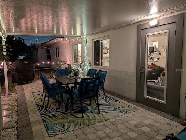 dining area featuring a textured wall and brick floor