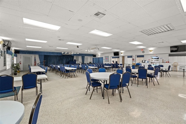 dining area with speckled floor, a paneled ceiling, and visible vents