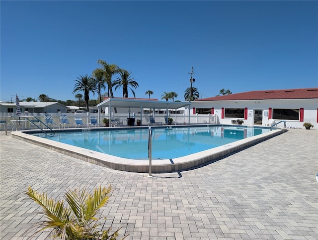 community pool featuring a patio and fence