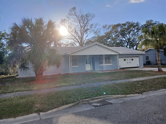 ranch-style home with a garage and a lawn