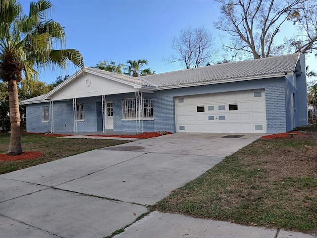 ranch-style house with a garage and a front lawn