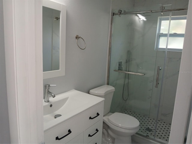 bathroom featuring walk in shower, vanity, and toilet