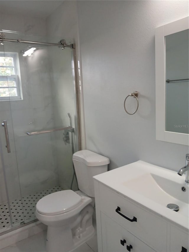 bathroom featuring toilet, vanity, and walk in shower