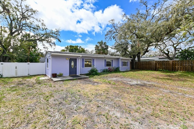 rear view of property with fence private yard, a gate, a yard, and stucco siding