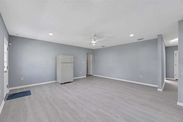 empty room with ceiling fan and light hardwood / wood-style flooring