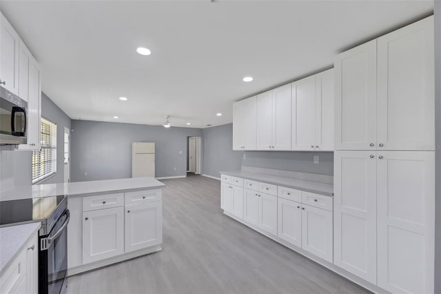 kitchen featuring white cabinets, stainless steel appliances, and light hardwood / wood-style floors