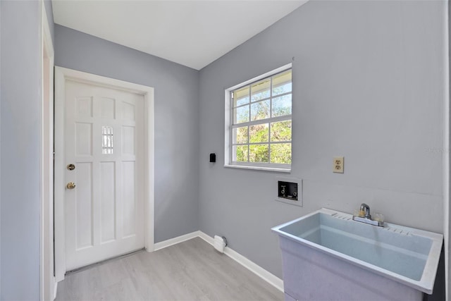 clothes washing area featuring washer hookup, light hardwood / wood-style flooring, and sink