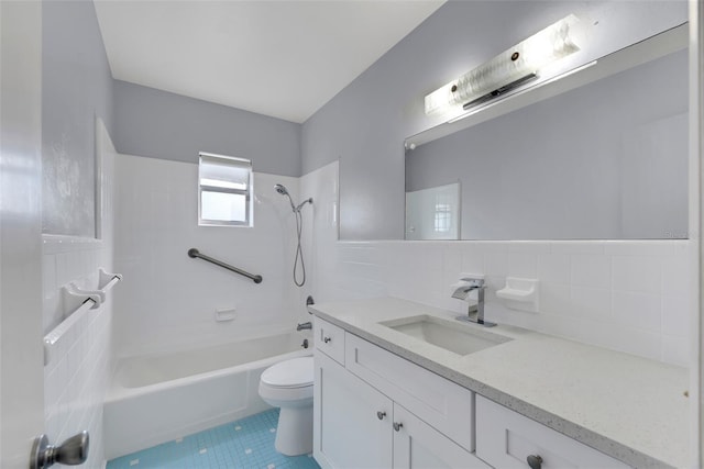 full bathroom with tiled shower / bath, toilet, tile walls, tile patterned floors, and vanity