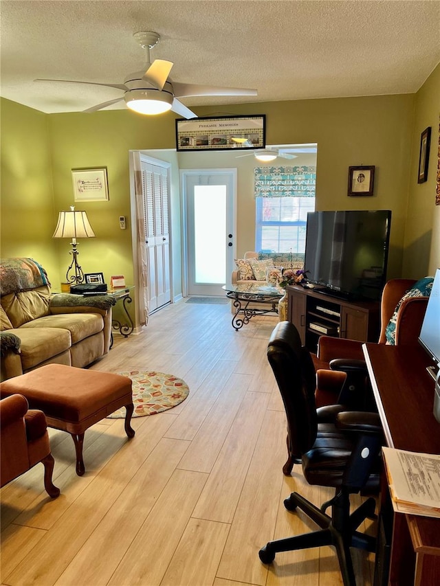 office space with a textured ceiling, ceiling fan, and light hardwood / wood-style flooring