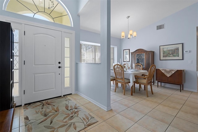 tiled entrance foyer with a notable chandelier and high vaulted ceiling