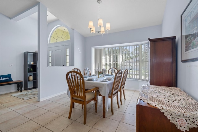 dining room featuring lofted ceiling, a notable chandelier, and light tile patterned floors