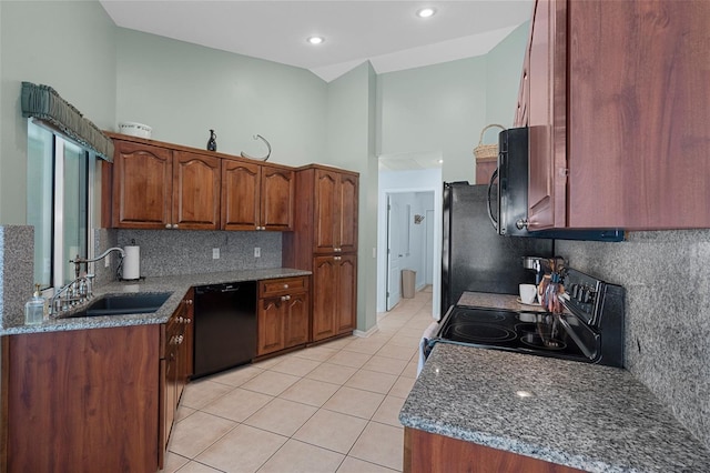 kitchen featuring sink, light tile patterned floors, dishwasher, range with electric cooktop, and dark stone counters