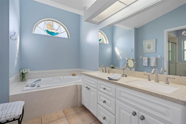 bathroom featuring tile patterned flooring, vanity, and a relaxing tiled tub